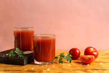 Two glasses of tomato juice are on the table.