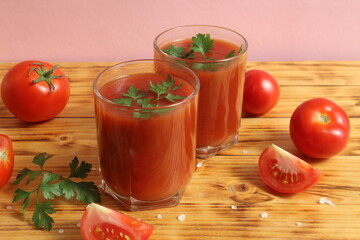Two glasses of tomato juice are on the table.	