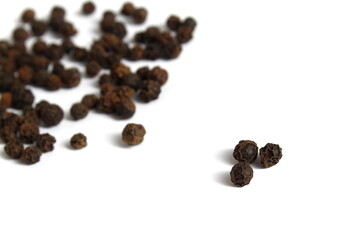 A bunch of black peppers with polka dots lie on a black background.