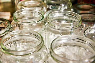 many glass washed transparent jars with a round neck stand ready for preparations for the winter