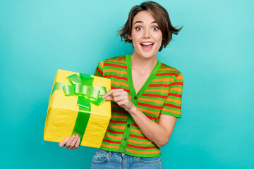 Portrait of overjoyed funky person hold open untie ribbon giftbox isolated on turquoise background