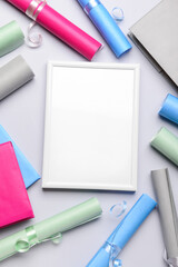 Blank frame with books and wrapping paper on light background