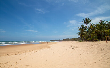 Garota distante com bola sozinha em praia do nordeste do Brasil