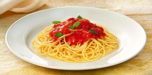 prato com delicioso espaguete com molho de tomate acompanhado com folhas de manjericão