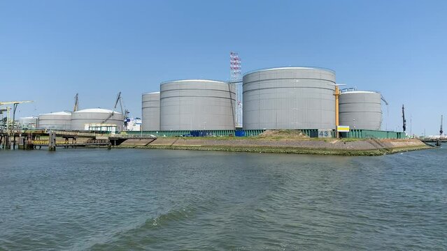 Terminal, industrial storage facility at Port, harbour of Rotterdam. Oil, petroleum and hazardous chemicals tanks, depot. View from a moving ship. Rotterdam, The Netherlands
