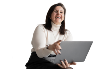 Using a laptop computer, the designer young woman laughs and looks away. An office employee, a young entrepreneur in the office.