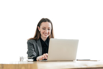 A woman uses a laptop computer, a secretary workplace in the office. An office employee is a financier in modern clothes.