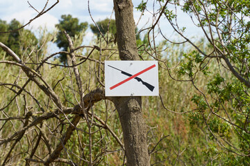 A sign is screwed onto the tree - Hunting is prohibited or Do not shoot.