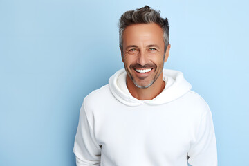 Mature man in white mockup sweater standing in light blue studio background 