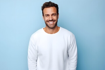 Fototapeta premium Man in white mockup sweater standing in light blue studio background 