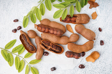 Tasty tamarinds, leaves and seeds on white background