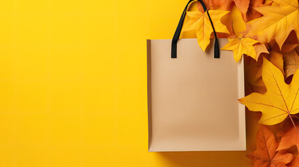 Paper eco-friendly shopping bag with fallen yellow maple leaves on orange background. Autumn seasonal sales mockup. Empty space for product placement or promotional text.