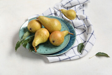 Plates with ripe pears on white background