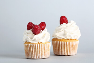 Tasty raspberry cupcakes on grey background
