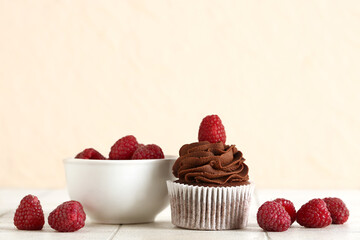 Tasty chocolate cupcake with raspberries on table