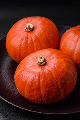 Beautiful fresh round pumpkins in orange color on a dark concrete background