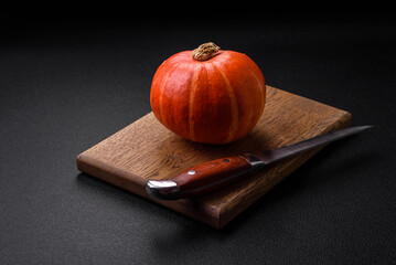 Beautiful fresh round pumpkins in orange color on a dark concrete background
