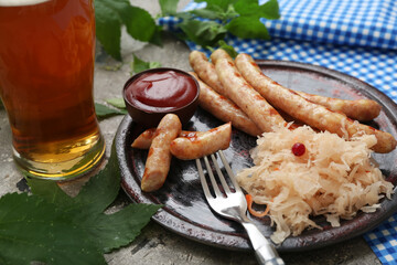 Plate with tasty Bavarian sausages, sauce, sauerkraut and glass of beer on grey background. Oktoberfest celebration