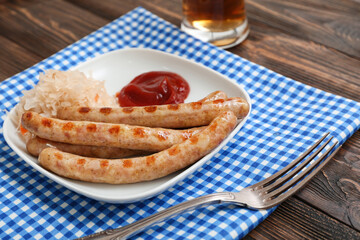 Plate with tasty Bavarian sausages, sauce and sauerkraut on wooden background. Oktoberfest celebration