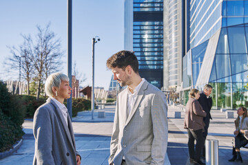 young entrepreneur couple talking. young caucasian man talking business with asian woman.