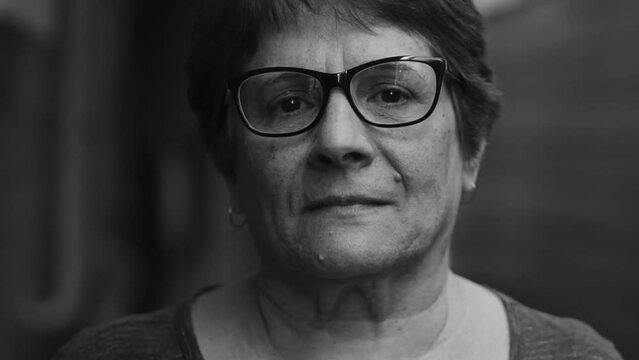 Close-up of a senior woman in dramatic monochromatic photography, black and white image portrait of an older person looking at camera