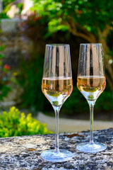 Tasting of premier cru sparkling rose wine with bubbles champagne with view on old houses of Hautvillers, where lived Benedictine monk how developed champagne wine, France.