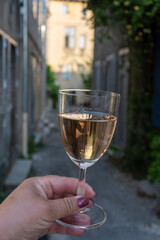 French rose dry wine from Provence in glass in sunny day with view on old streets of Arles town in sunny day