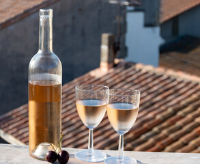 French cold rose dry wine from Provence in two glasses in sunny day with view on old roofs of Arles...