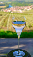 Tasting of premier cru sparkling rose wine with bubbles champagne with view on green pinot noir, meunier vineyards of Hautvillers, France.