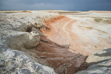 Hills of chalk and limestone and slopes of multi-colored mountains with weathering and washouts from water, colored relief in the steppe