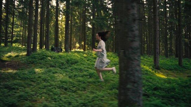 A pretty woman walks dreamily through the early forest full of zest for life
