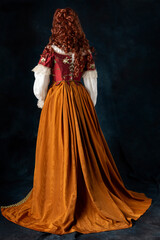 A mannequin wearing a 16th to 18th century historical costume against a dark studio backdrop