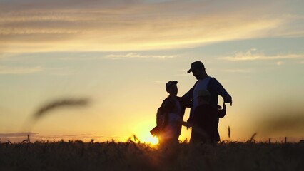 Loving parents together with their children. Dad, mom, child, daughter, son rejoicing, hugging at sunset in field, Silhouette. Happy family of farmers in wheat field. Concept of dream of happy future