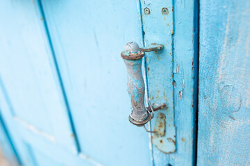 vintage old blue color door handle. peeling paint on wood doors