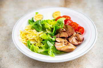 salad chicken liver, pasta, tomato, green leaf lettuce, boiled egg, farfalle snack meal food on the table copy space food background rustic top view
