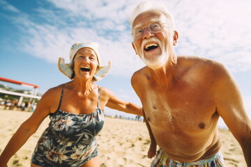 An elderly couple playing volleyball on the beach