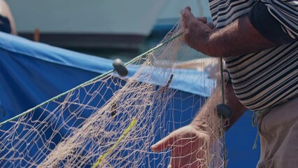Fishermen at Work Cleaning Fishing Nets Footage. - Powered by Adobe