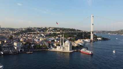 Fototapeta premium A drone shot of the Grand Mecidiye Mosque, Ortaköy, Istanbul, with the skyline of the city and Bosphorus in the background