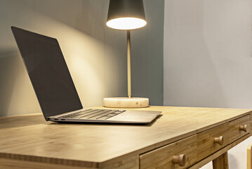 A laptop on a natural colored wooden