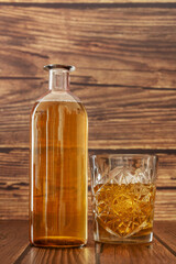 A bottle and a carved glass filled