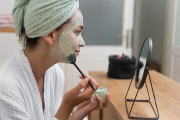Skin Refresh: Draped in a towel, she indulges in a facial mask after her bath, focusing on...