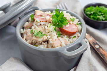 Traditional South Carolina chicken bog dish with smocked sausages, in small pot, horizontal