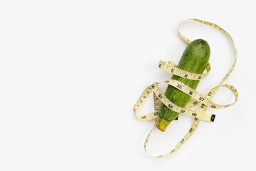 Zucchini with measuring tape on white background
