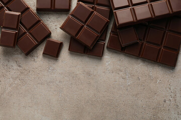 Delicious dark chocolate on grey table, flat lay. Space for text