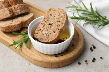 Bowl of organic balsamic vinegar with oil served with spices and bread slices on beige table