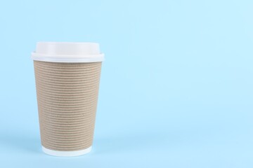 Paper cup with plastic lid on light blue background, space for text. Coffee to go
