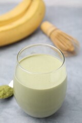 Glass of tasty matcha smoothie on light grey table