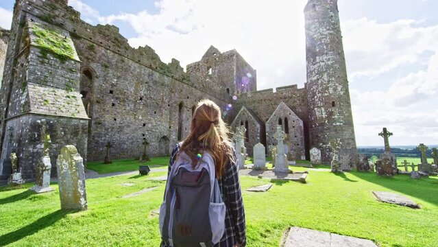 Woman walking through graveyard in cathedral at Rock of Cashel Ireland