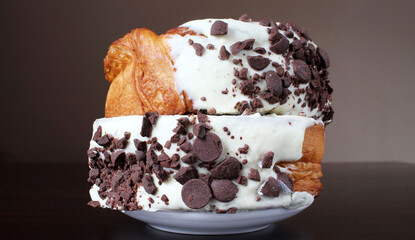 Dos croissant roll encimados con chocolate blanco y chispas de chocolate negro. 