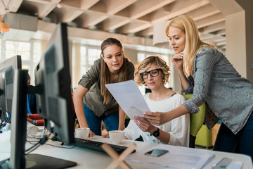 Young and diverse group of women working together in a startup company office